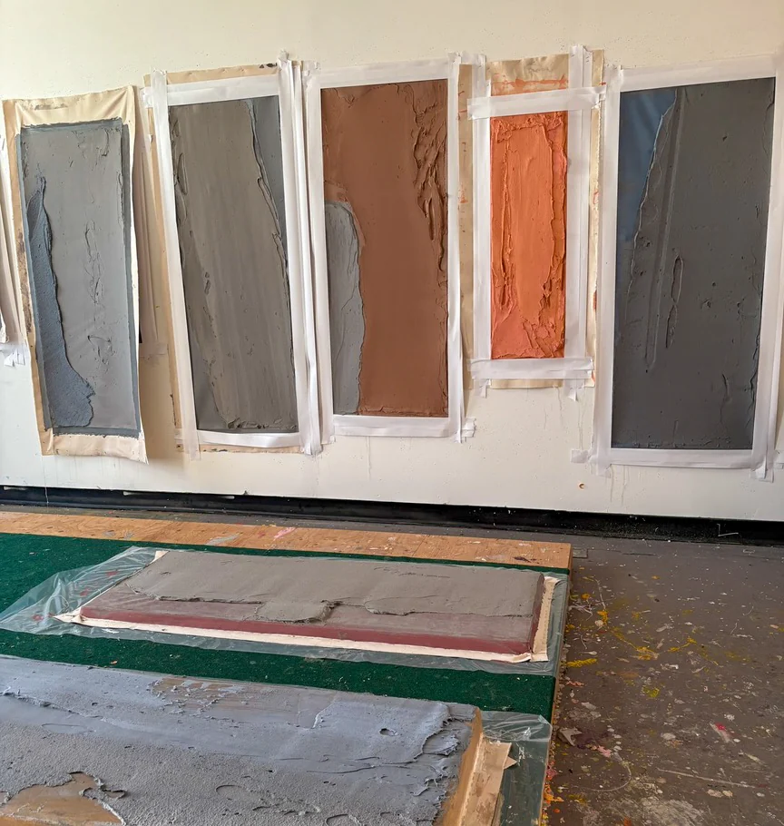 Mitchel Smith standing in front of his paintings